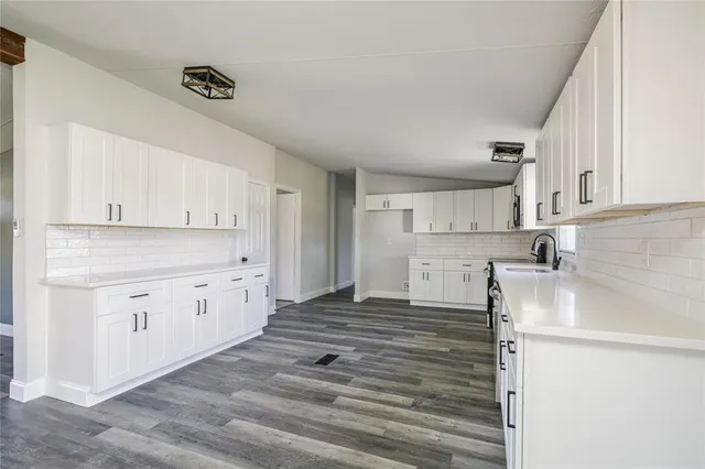a kitchen with granite countertop white cabinets and white appliances