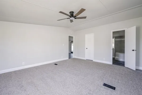 an empty room with closet and ceiling fan