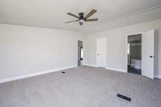 an empty room with closet and ceiling fan