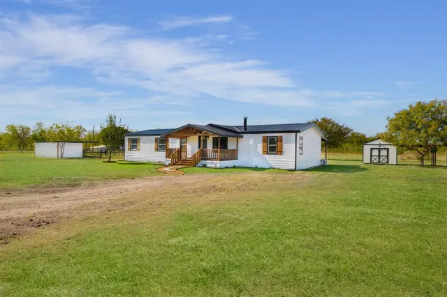 a front view of a house with a big yard