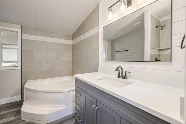 a bathroom with a sink a toilet a mirror and shower