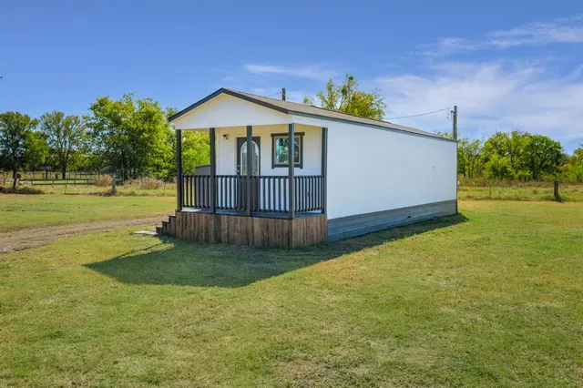 a view of a house with a yard and sitting area