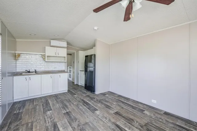 a kitchen with granite countertop white cabinets and refrigerator