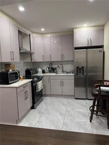 a kitchen with a sink a refrigerator and cabinets
