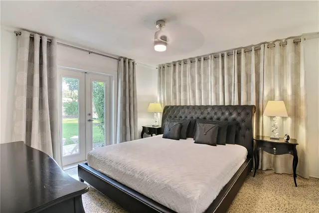 a large bed sitting in a bedroom next to a window