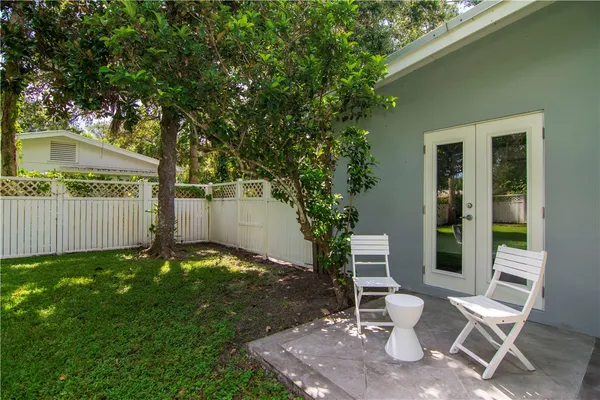 a view of a chair and table in backyard of the house