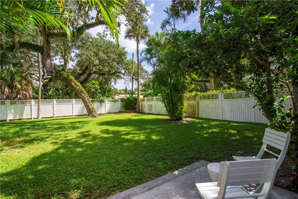 a view of a backyard with table and chairs and a large tree