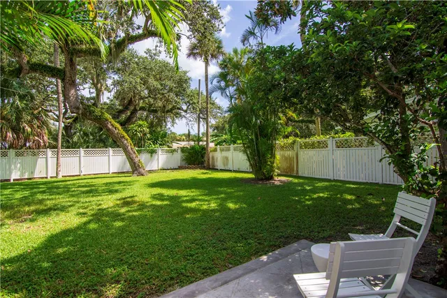 a view of a backyard with table and chairs and a large tree