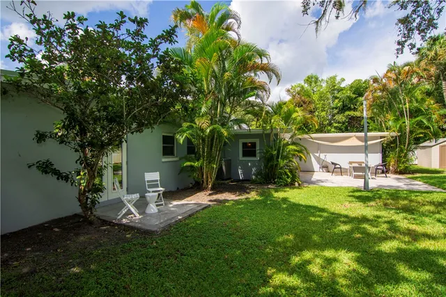 a view of a house with a yard and sitting area