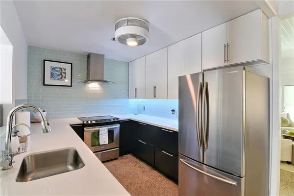a kitchen with stainless steel appliances a refrigerator sink and cabinets