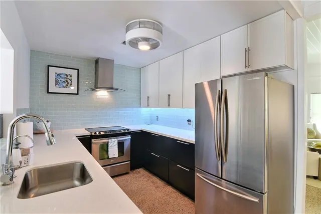 a kitchen with stainless steel appliances a refrigerator sink and cabinets