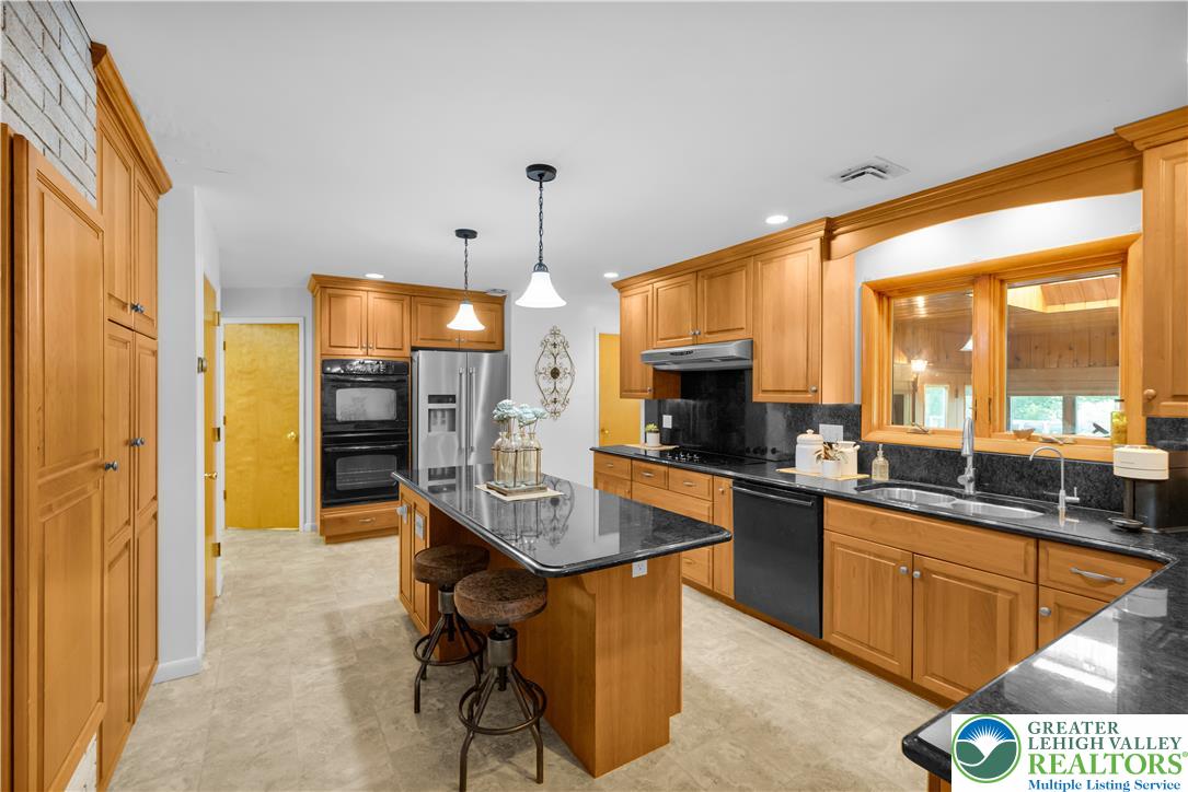 5747 Kernsville Road Orefield, PA 18069 - Photo 14 of 56 a kitchen with stainless steel appliances kitchen island granite countertop a sink and cabinets