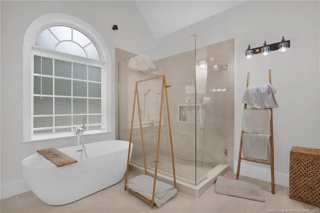 a spacious bathroom with a glass shower door and a window