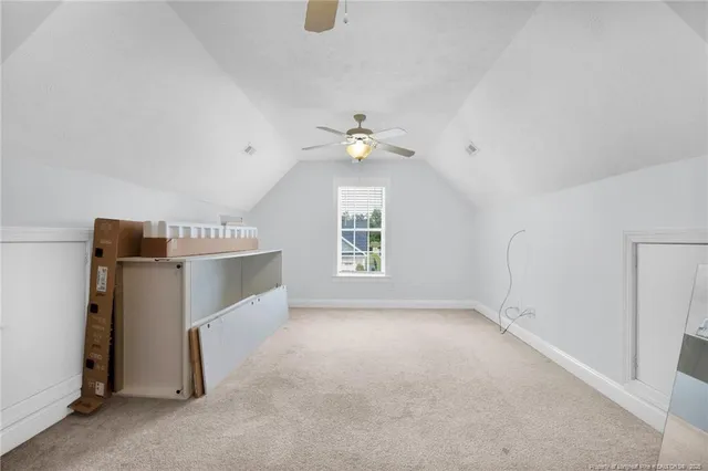 an empty room with windows and ceiling fan