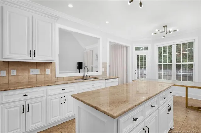 a kitchen with sink cabinets and chandelier