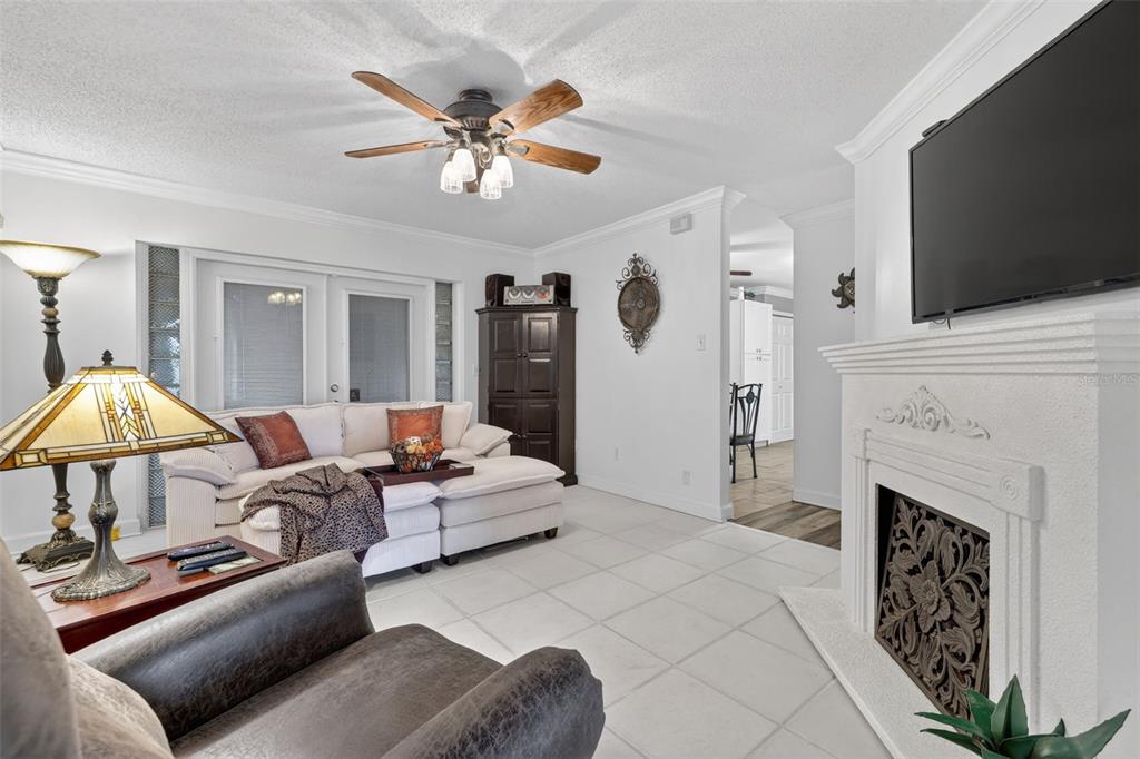 575 Tiberon Cove Road Longwood, FL 32750 - Photo 10 of 56 a living room with furniture a flat screen tv and a fireplace