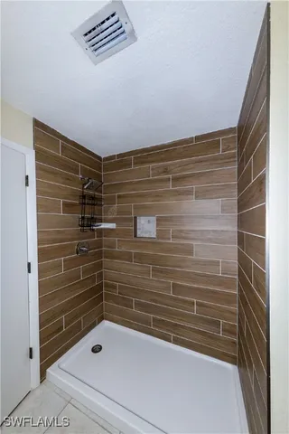 a bathroom with a tub a sink and mirror