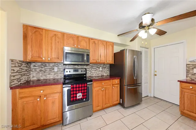 a kitchen with granite countertop stainless steel appliances a refrigerator cabinets and a stove top oven