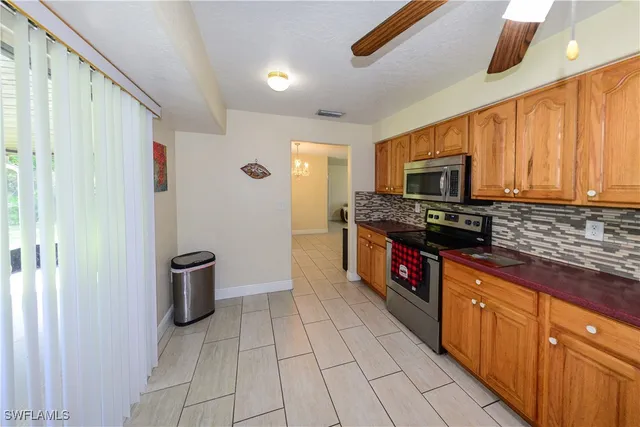 a large kitchen with stainless steel appliances granite countertop a stove a sink and a microwave