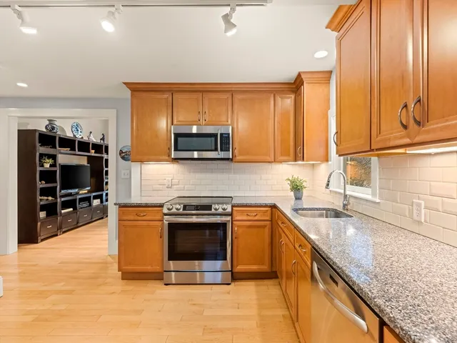 a kitchen with stainless steel appliances granite countertop a stove sink and microwave
