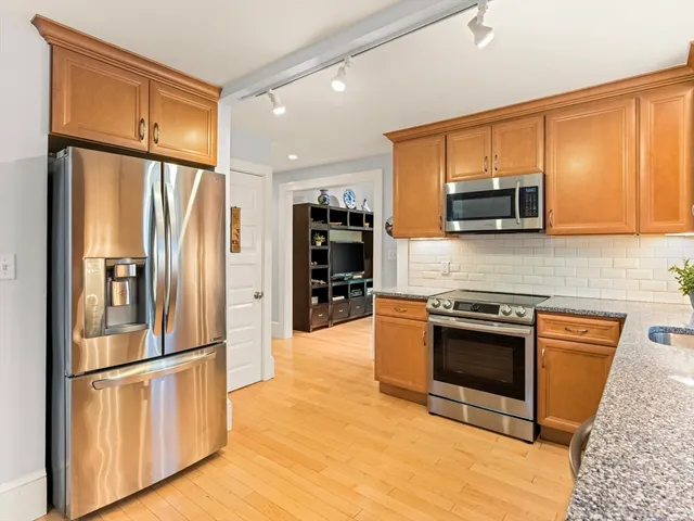 a kitchen with stainless steel appliances granite countertop a refrigerator stove and microwave