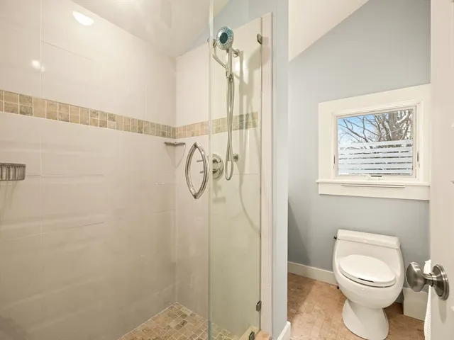 a bathroom with a shower a toilet and a shower