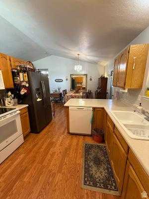 641 East Greystone Way Tooele, UT 84074 - Photo 5 of 30 Kitchen featuring wood-finish flooring, light-toned countertops, and wood cabinetry