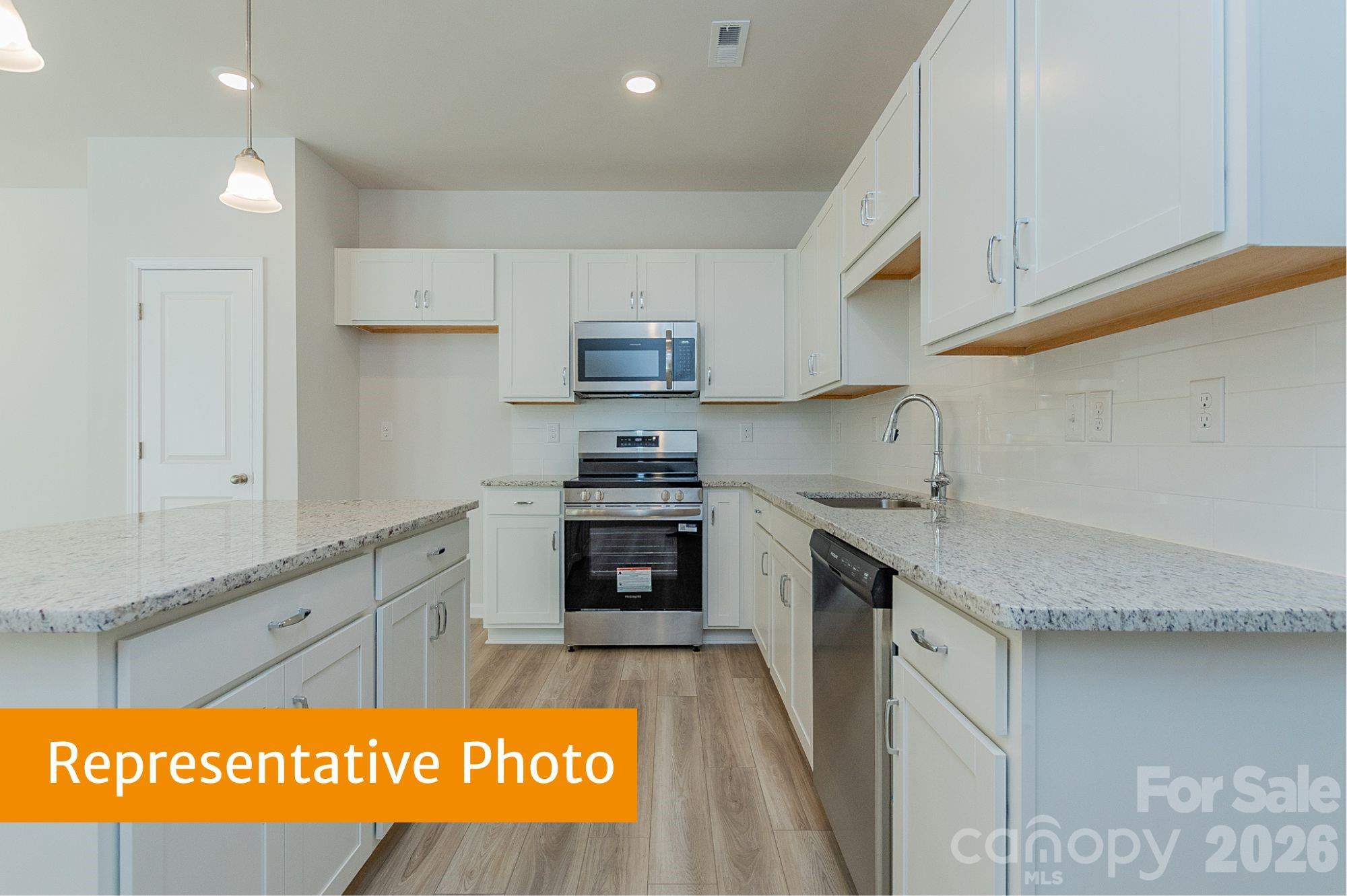 5613 Ringneck Road Charlotte, NC 28216 - Photo 4 of 29 a kitchen with stainless steel appliances granite countertop a sink and cabinets