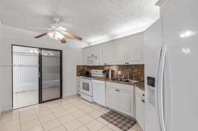 a kitchen with white cabinets and appliances