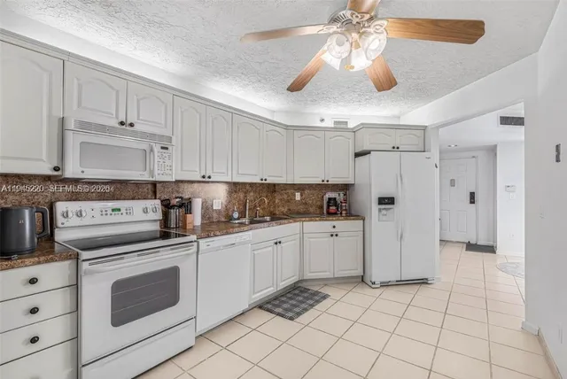 a kitchen with white cabinets and white appliances