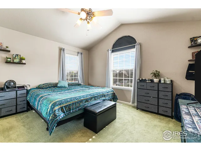 a bedroom with a bed and a flat tv screen on the dresser