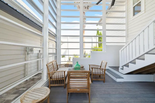 a kitchen with stainless steel appliances granite countertop a stove a refrigerator a kitchen island a dining table and chairs with wooden floor