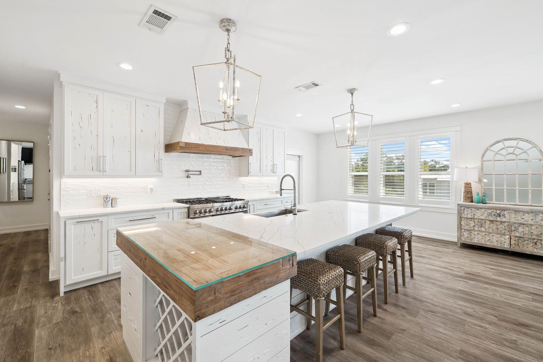 1984 South Co Highway 83 Santa Rosa Beach, FL 32459 - Photo 23 of 70 a kitchen with stainless steel appliances granite countertop a stove a refrigerator a kitchen island a dining table and chairs with wooden floor