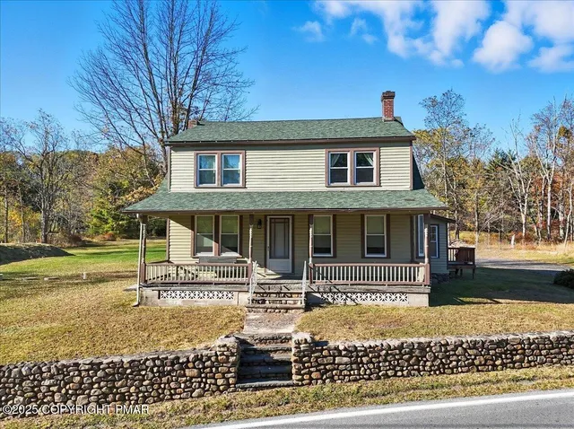 a view of house with yard and sitting area
