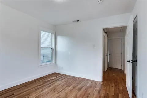 a view of a room with wooden floor and a window