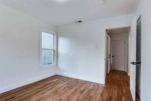 a view of a room with wooden floor and a window