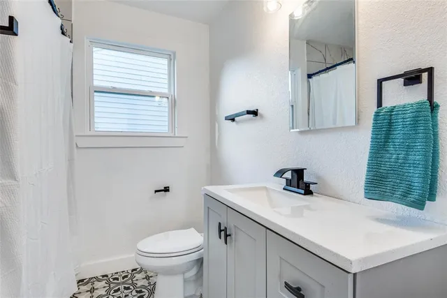 a bathroom with a sink toilet and a window