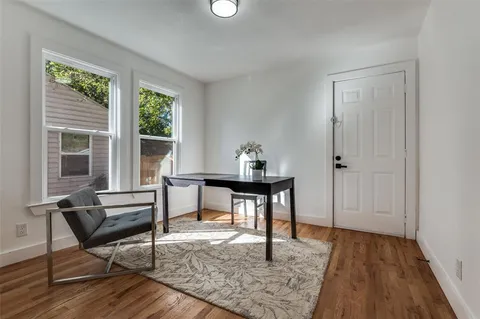 a view of a workspace with furniture and a window