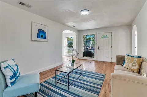 a living room with furniture and wooden floor