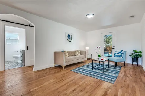 a living room with furniture and a wooden floor