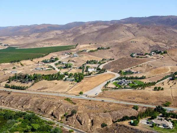 an aerial view of mountain with residential houses covered by trees