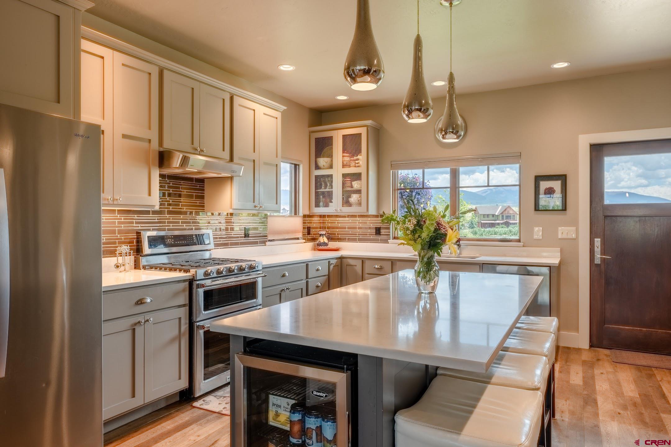 142 Larkspur Loop Crested Butte, CO 81224 - Photo 17 of 35 a kitchen with stainless steel appliances a dining table chairs refrigerator and cabinets