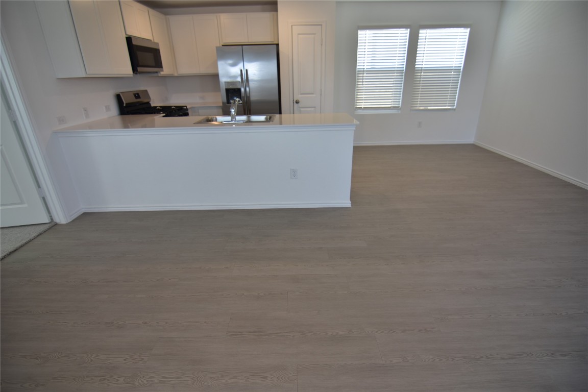 275 Bugbee Kyle, TX 78640 - Photo 10 of 39 a living room with stainless steel appliances granite countertop a refrigerator a stove a sink a window and cabinets