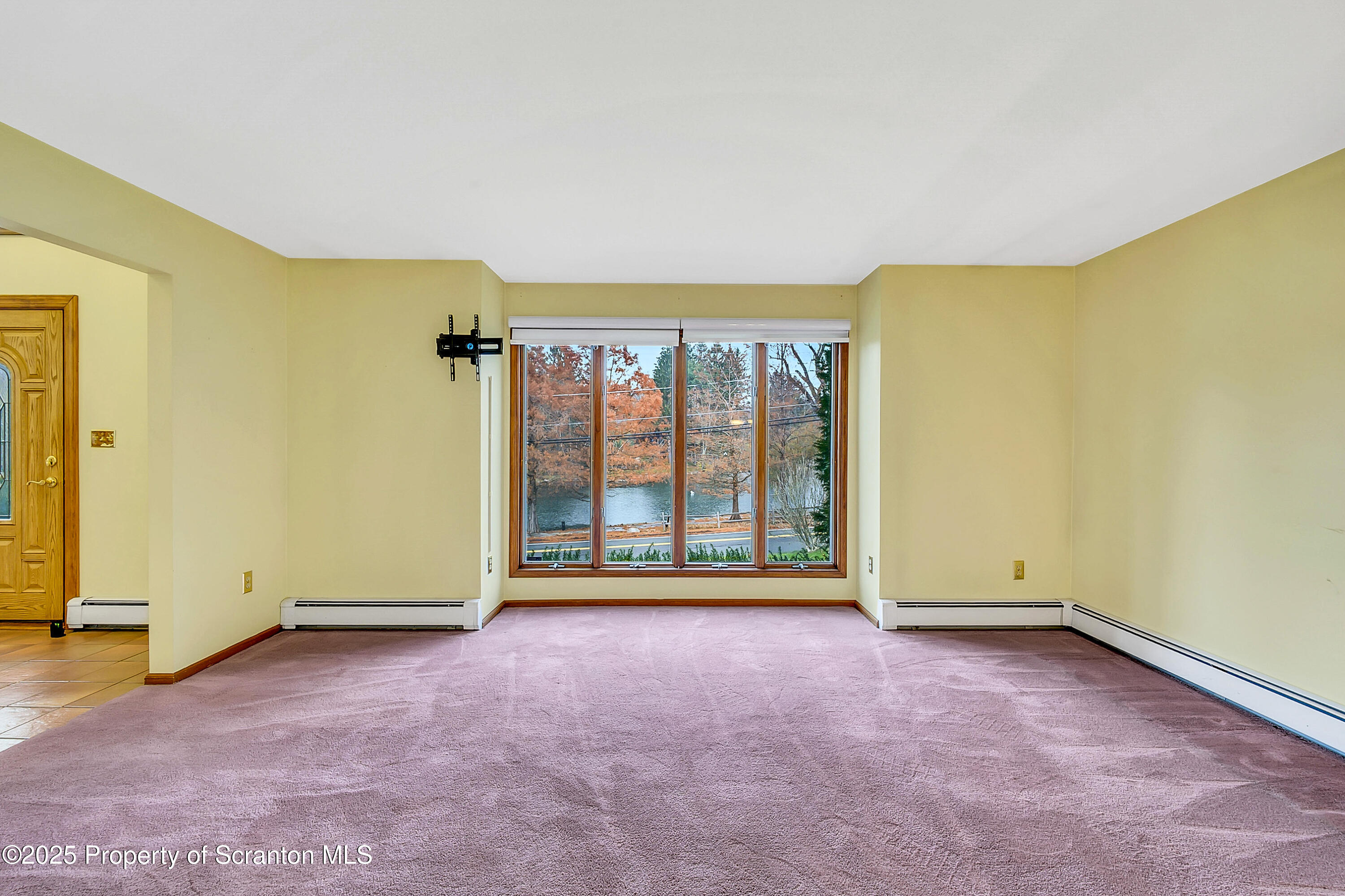 804 Fairview Road Clarks Summit, PA 18411 - Photo 13 of 49 an empty room with a fireplace and a large window