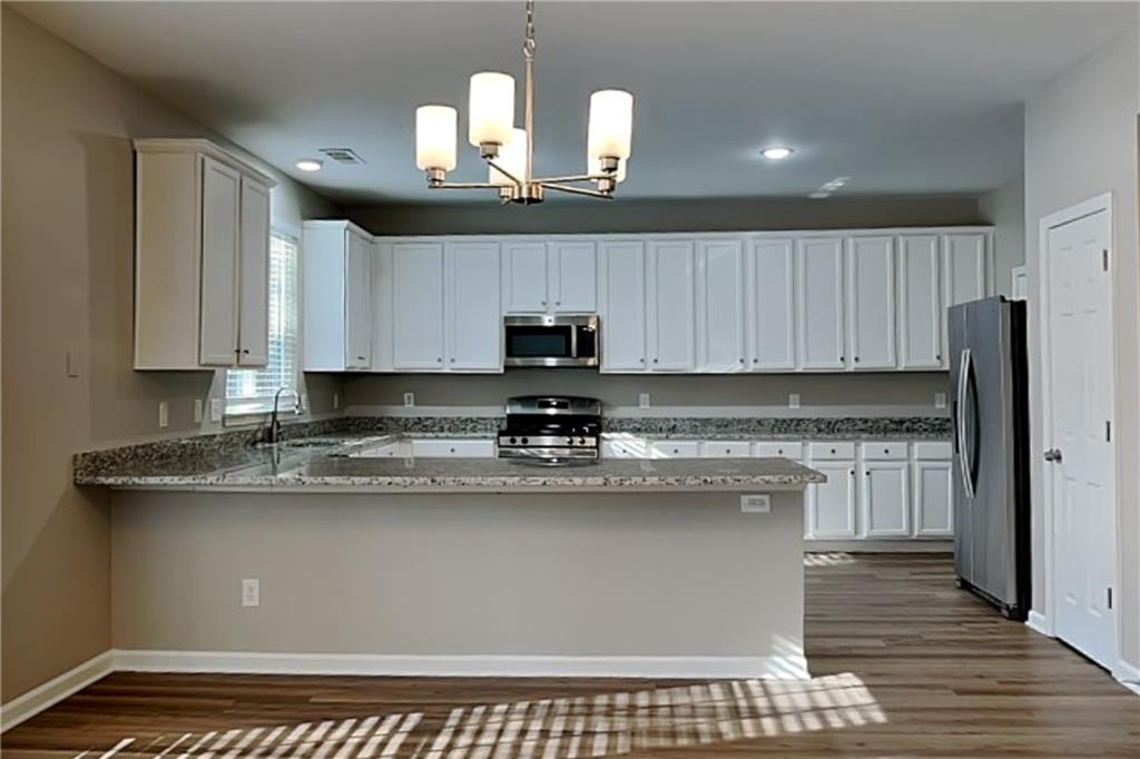 89 Candy Lilly Court Dallas, GA 30157 - Photo 5 of 19 a kitchen with kitchen island granite countertop a sink cabinets and stainless steel appliances