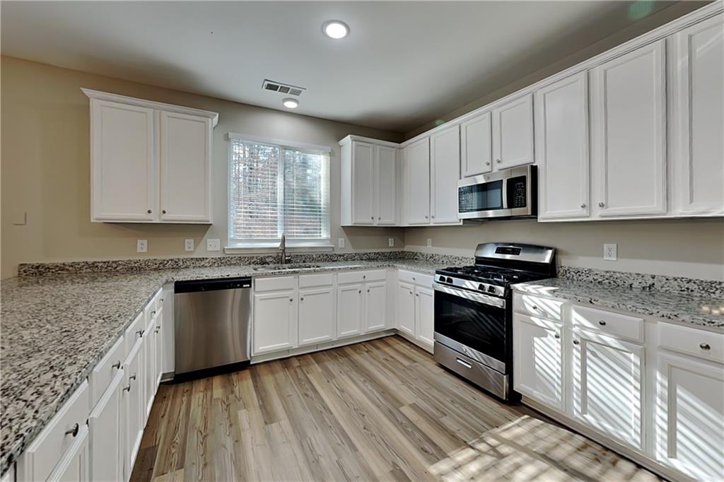 89 Candy Lilly Court Dallas, GA 30157 - Photo 6 of 19 a kitchen with stainless steel appliances granite countertop a stove a sink and a microwave
