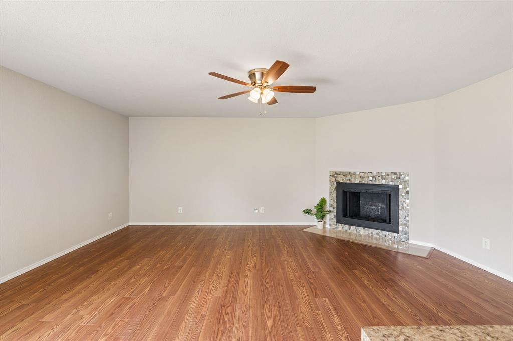 5620 Perrin Street The Colony, TX 75056 - Photo 4 of 31 an empty room with a fireplace and a ceiling fan
