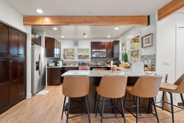 a kitchen with stainless steel appliances granite countertop a refrigerator microwave and stove