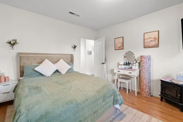 a bedroom with a bed and wooden floor