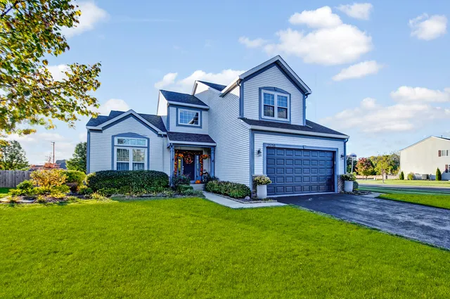a front view of a house with a yard and garage